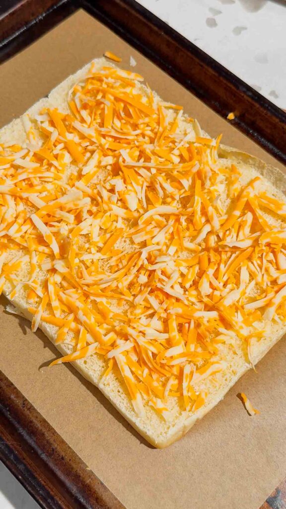 shredded cheddar on the bottom halves of kings Hawaiian rolls