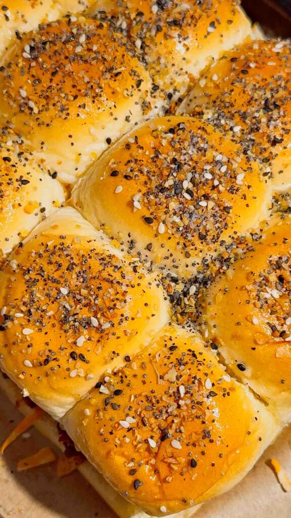 BBQ Bacon Cheeseburger Sliders are the ultimate easy dinner or party food! Juicy ground beef, diced onions, crumbled bacon, and BBQ sauce piled onto buttery King’s Hawaiian rolls, topped with shredded cheddar, crispy fried onions, and everything bagel seasoning. Perfect for game day, potlucks, weeknight dinners, or crowd-pleasing appetizers. Save this cheesy slider recipe! 🍔🔥