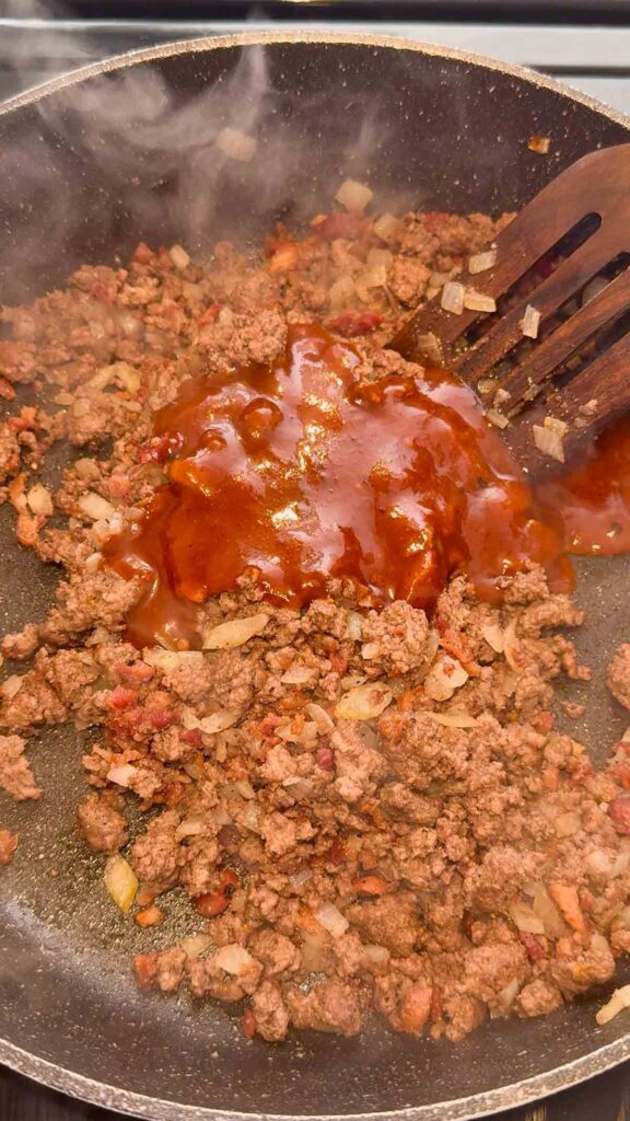 bbq sauce added to skillet with cooked ground beef mixture