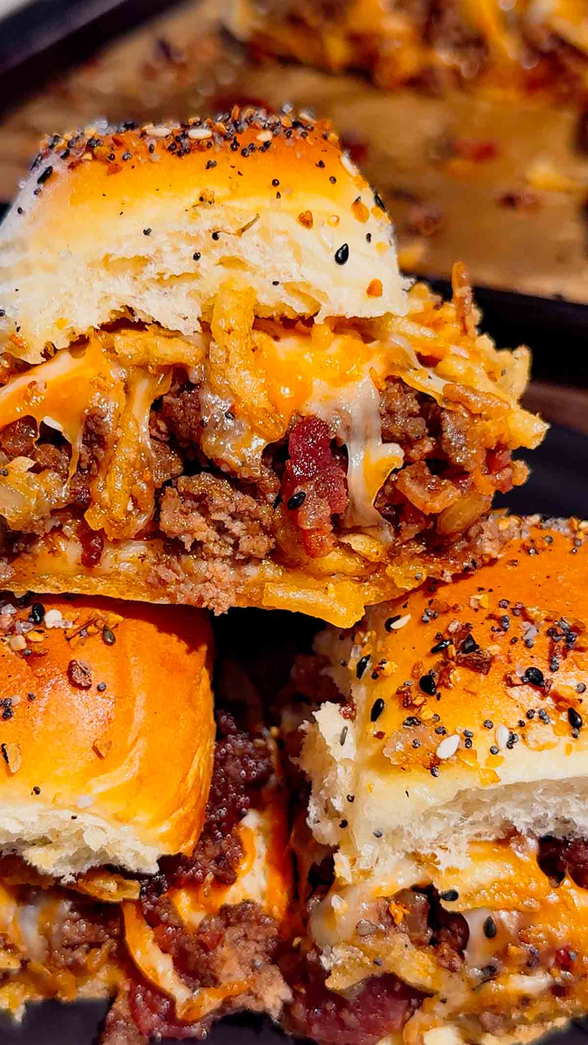 BBQ Bacon Cheeseburger Sliders are the ultimate easy dinner or party food! Juicy ground beef, diced onions, crumbled bacon, and BBQ sauce piled onto buttery King’s Hawaiian rolls, topped with shredded cheddar, crispy fried onions, and everything bagel seasoning. Perfect for game day, potlucks, weeknight dinners, or crowd-pleasing appetizers. Save this cheesy slider recipe! 🍔🔥