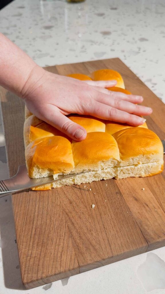 slicing open some king's hawaiian rolls