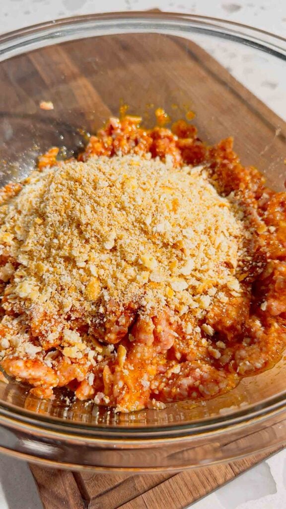 Ritz cracker crumbs added to bowl with ground pork mixture
