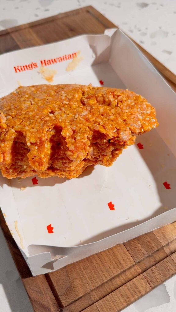 ground pork mixture dumped into empy hawaiian rolls box