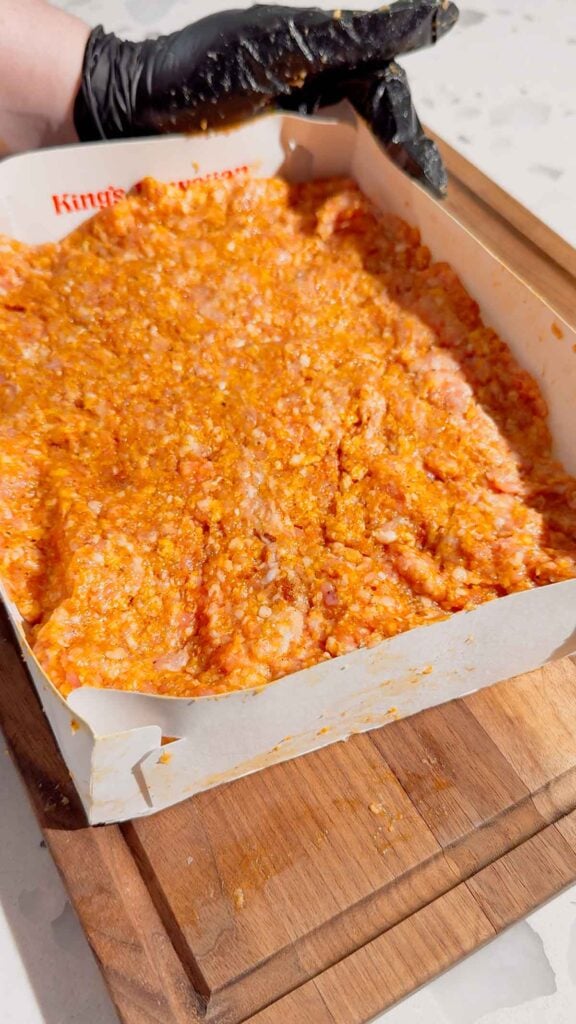 ground pork mixture pressed into hawaiian roll carboard box