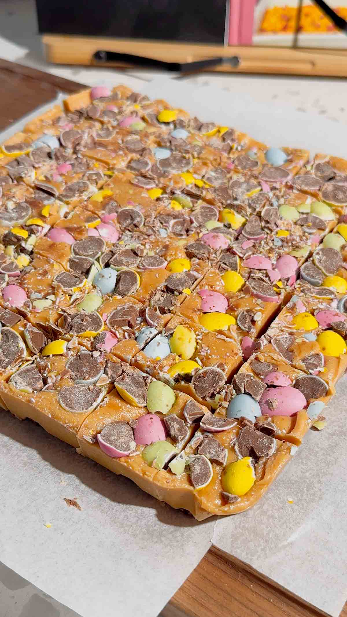 Mini Egg Peanut Butter Cup Fudge is the ultimate easy no bake dessert for Easter and spring parties. This microwave fudge recipe is made with vanilla frosting, peanut butter chips and smooth peanut butter for a rich and creamy texture. Loaded with mini Reese’s peanut butter cups and crushed Cadbury mini eggs, this dessert is perfect for peanut butter lovers. If you’re looking for easy Easter desserts, no bake fudge recipes, simple desserts for a crowd or quick holiday treats, this one is a must try. Great for gifting, dessert trays, potlucks and family gatherings, this sweet treat is colourful, fun and incredibly easy to make. Save this easy fudge recipe for your Easter dessert ideas.