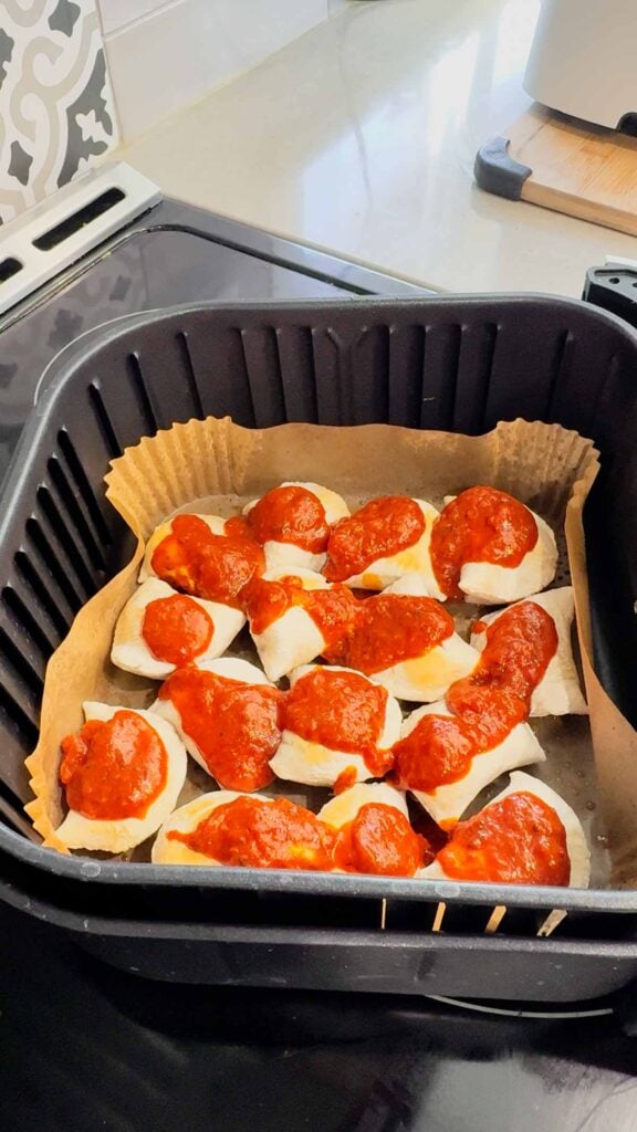 pizza sauce on top of piergoies in an air fryer