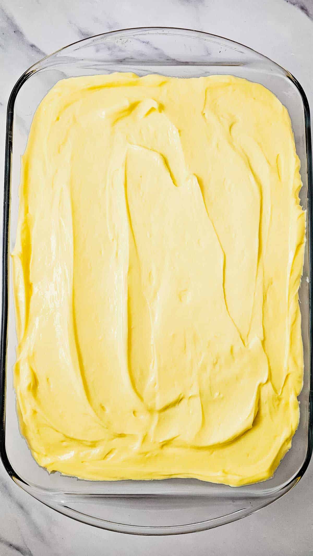 cream cheese pudding mixture spread over cake in baking dish