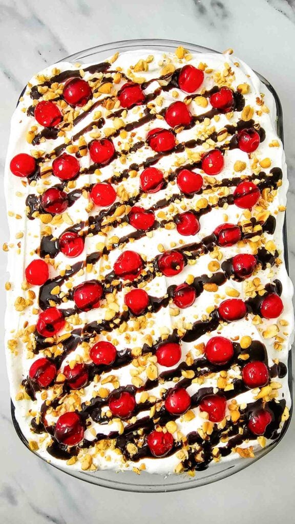 Banana Split Cake is the ultimate easy dessert recipe for anyone who loves classic banana split flavors in a soft baked cake. This layered dessert starts with a moist yellow cake base and is topped with bananas, crushed pineapple, fluffy whipped topping, chocolate drizzle, and maraschino cherries for the perfect sweet finish. If you’re searching for easy cake recipes, banana desserts, pineapple desserts, potluck desserts, summer desserts, or crowd pleasing party desserts, this Banana Split Cake recipe is a must-try. Great for birthdays, BBQs, family gatherings, holidays, and make ahead desserts, this colorful treat is simple to prepare and always a hit with both kids and adults who love fun retro dessert recipes.