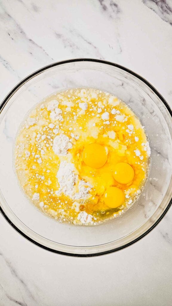 eggs, oil, pineapple juice and cake mix in a glass mixing bowl