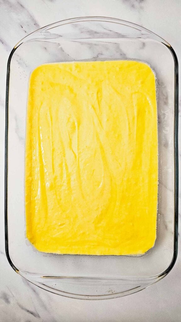 yellow cake batter in a glass 9 x 13 inch baking dish