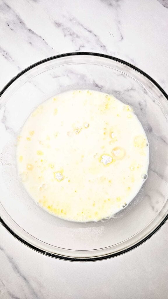 milk added to glass bowl with pudding mix