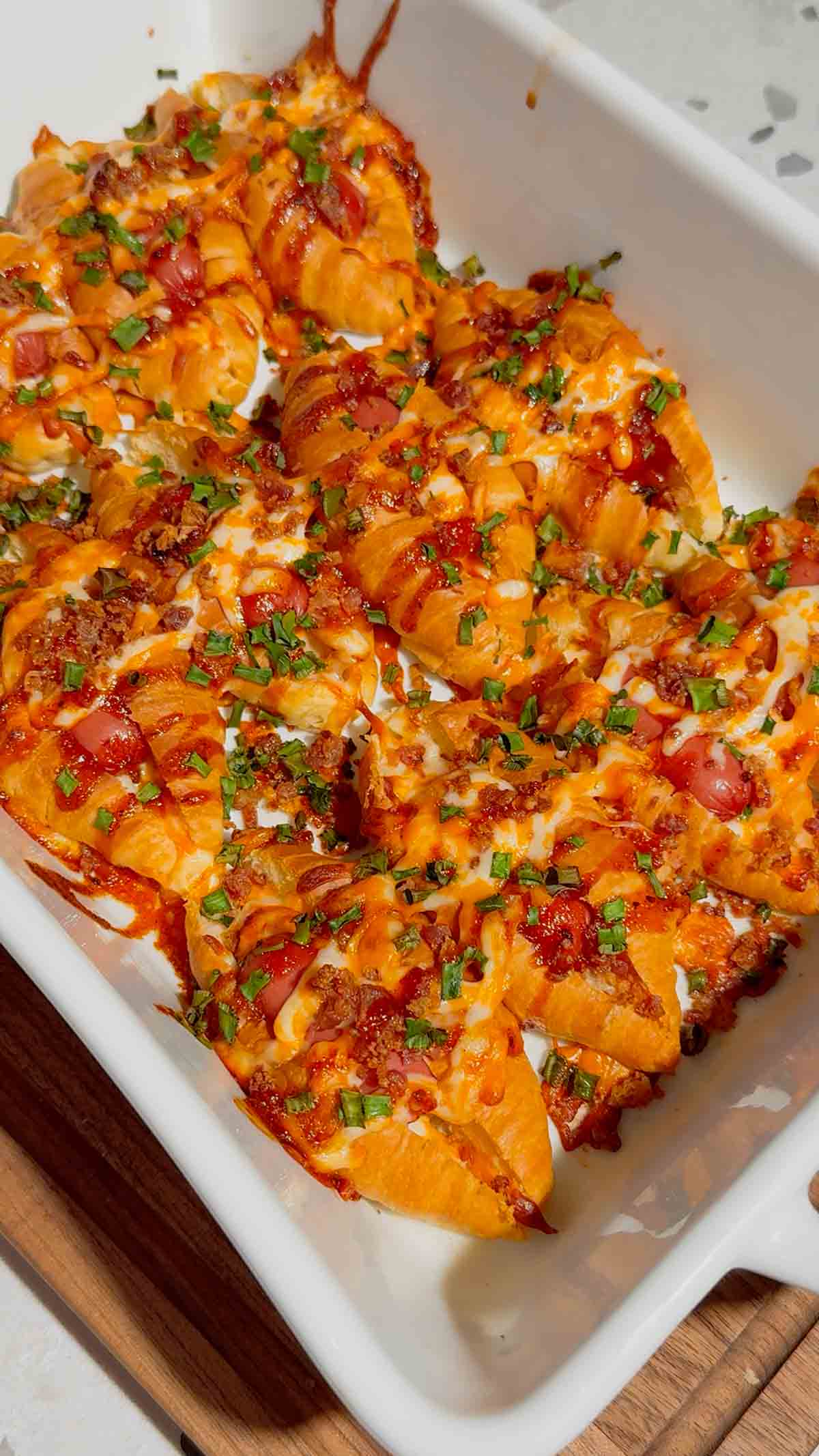 Looking for the ultimate easy party appetizer? These Cheesy Bacon Mini Croissant Dogs are loaded with smoky bacon, melty cheddar cheese, cocktail wieners and BBQ sauce baked inside buttery mini croissants for the perfect bite-sized snack. This easy appetizer recipe is perfect for game day food, football parties, holiday appetizers, movie night snacks and fun family dinners. Using store bought mini croissants keeps this recipe quick, simple and packed with comfort food flavor. If you love pigs in a blanket, cheesy hot dog recipes, bacon appetizers, easy finger foods and crowd pleasing party snacks, these loaded mini croissant dogs are a must-try recipe everyone will be grabbing straight from the pan for seconds.