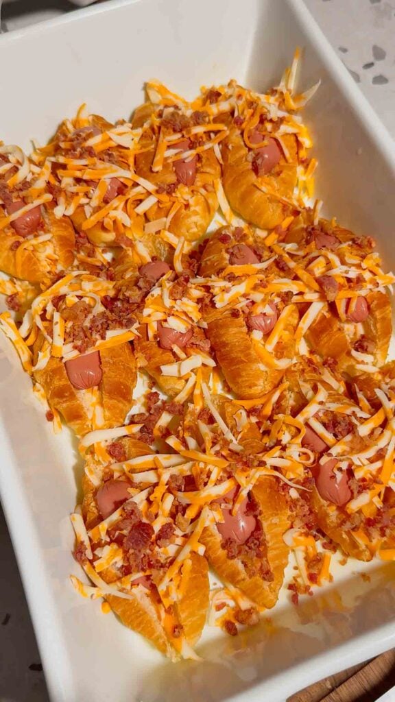 crumbled bacon and shredded cheddar on top of mini croissant dogs