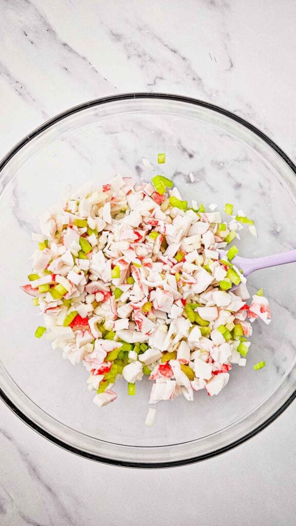 diced onions, crab meat and diced celery stirred together in a mixing bowl
