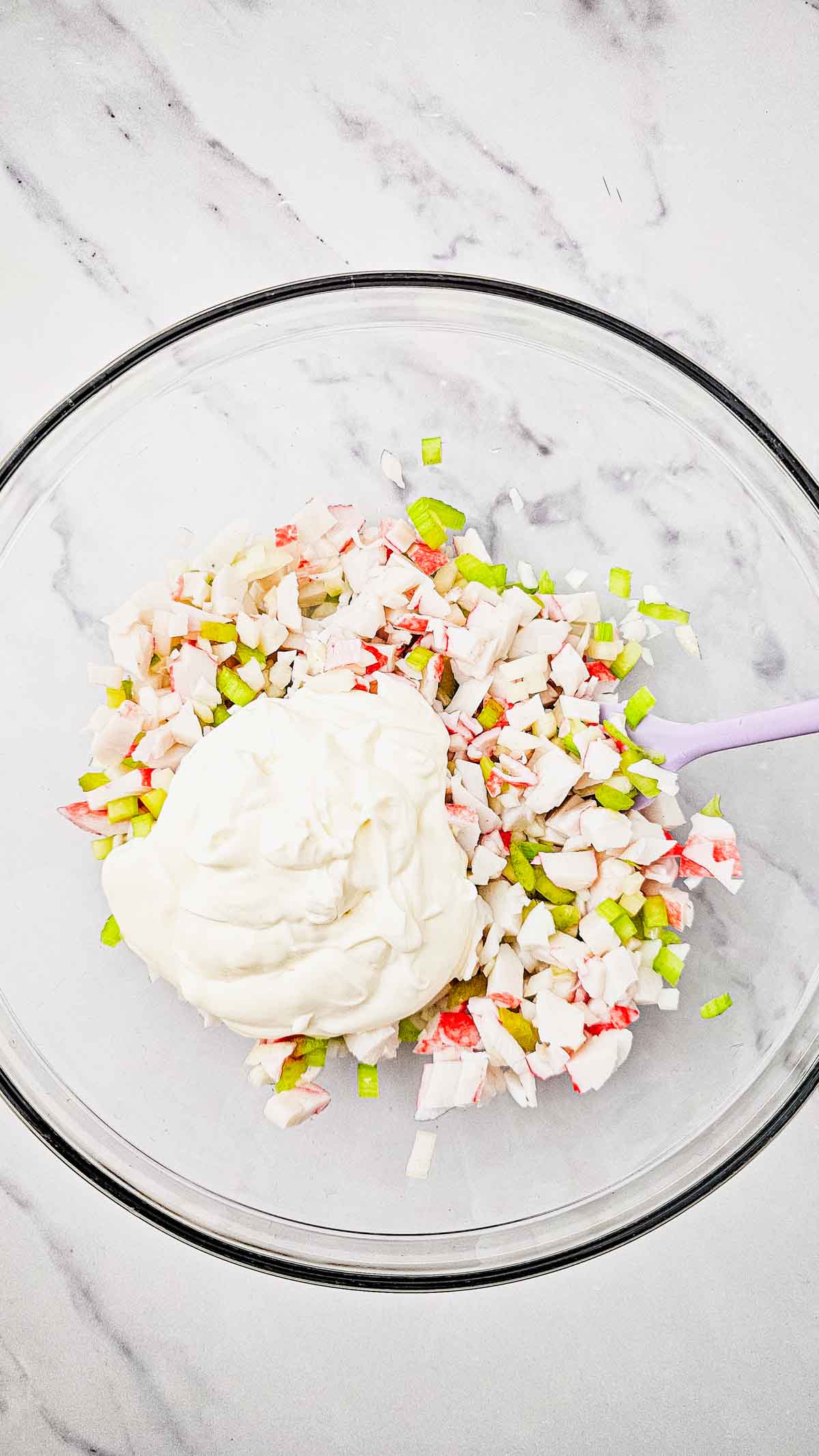 mayo based dressing and crab salad ingredients in a mixing bowl