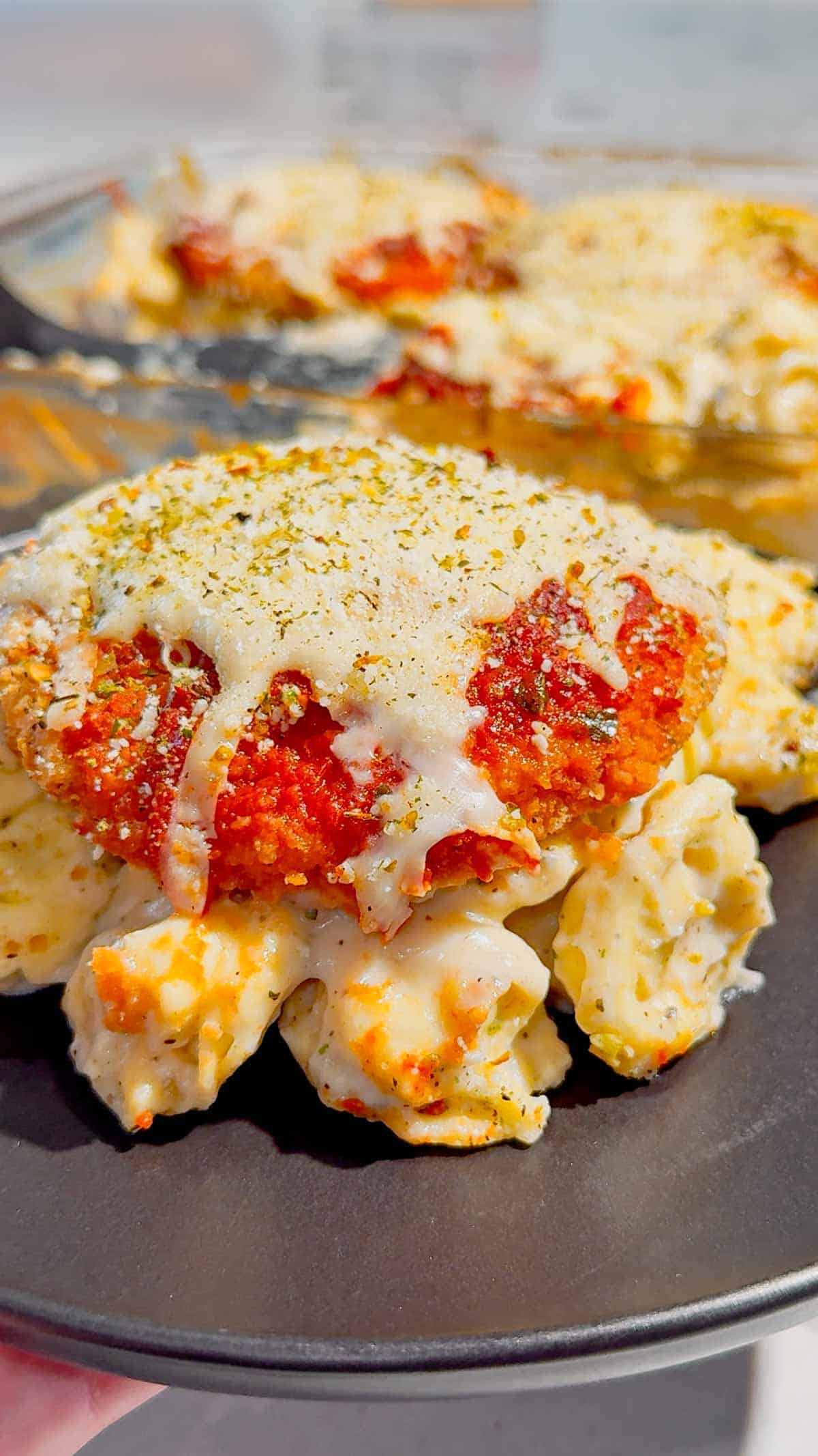 This Dump and Bake Chicken Parm Tortellini Alfredo is the ultimate easy comfort food dinner for busy weeknights, lazy dinners and family meals everyone will love. Made with refrigerated cheese and bacon tortellini, creamy jarred Alfredo sauce, crispy breaded chicken burgers, rich marinara sauce and gooey melted mozzarella, this baked pasta casserole comes together in one dish with almost no prep. If you love easy chicken parm recipes, dump dinners, baked tortellini recipes, cheesy pasta casseroles and simple family dinner ideas, this recipe is a must-try. Perfect for quick weeknight dinners, freezer meals, potlucks and cozy comfort food cravings, this creamy chicken parmesan tortellini bake is loaded with flavour, cheesy layers and hearty pasta goodness in every bite.