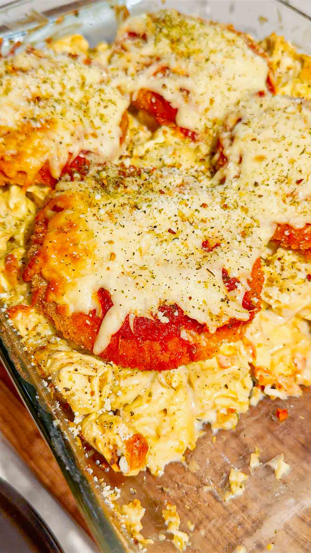 This Dump and Bake Chicken Parm Tortellini Alfredo is the ultimate easy comfort food dinner for busy weeknights, lazy dinners and family meals everyone will love. Made with refrigerated cheese and bacon tortellini, creamy jarred Alfredo sauce, crispy breaded chicken burgers, rich marinara sauce and gooey melted mozzarella, this baked pasta casserole comes together in one dish with almost no prep. If you love easy chicken parm recipes, dump dinners, baked tortellini recipes, cheesy pasta casseroles and simple family dinner ideas, this recipe is a must-try. Perfect for quick weeknight dinners, freezer meals, potlucks and cozy comfort food cravings, this creamy chicken parmesan tortellini bake is loaded with flavour, cheesy layers and hearty pasta goodness in every bite.