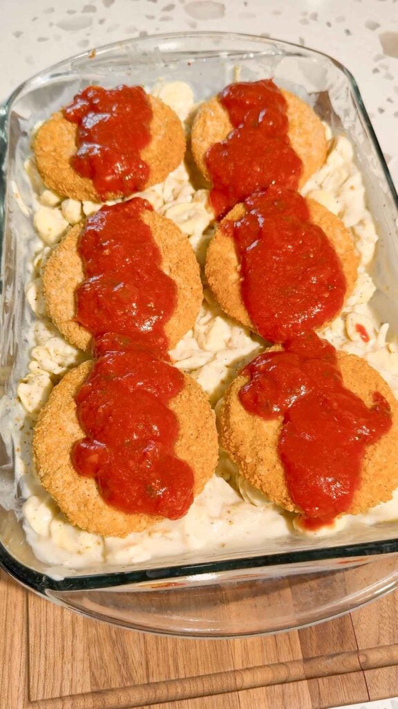 marinara sauce poured over breaded chicken burgers