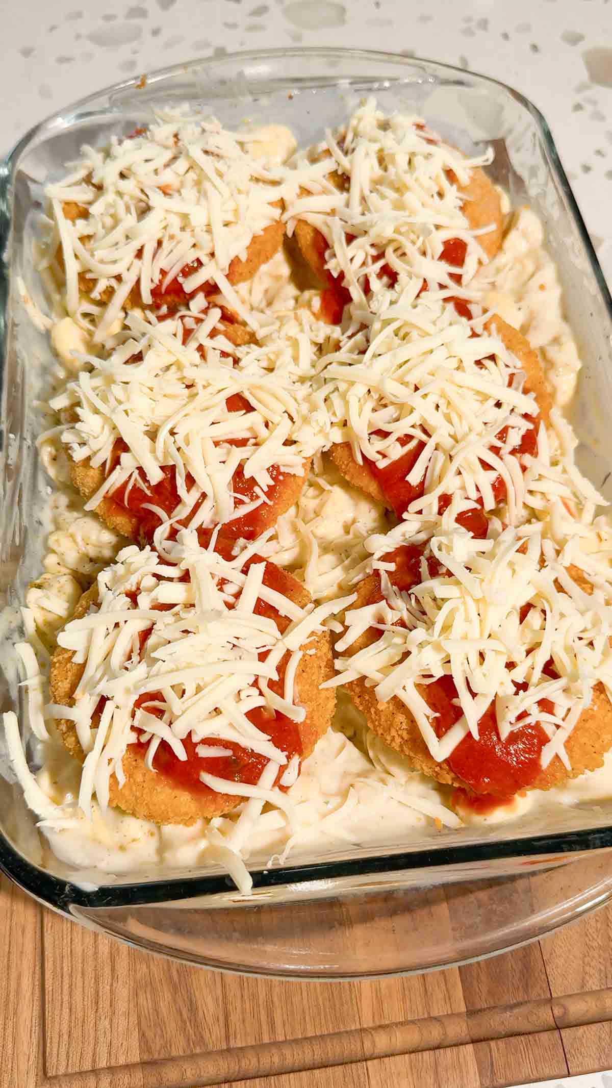 shredded mozzarella and marinara sauce on top of bread chicken patties