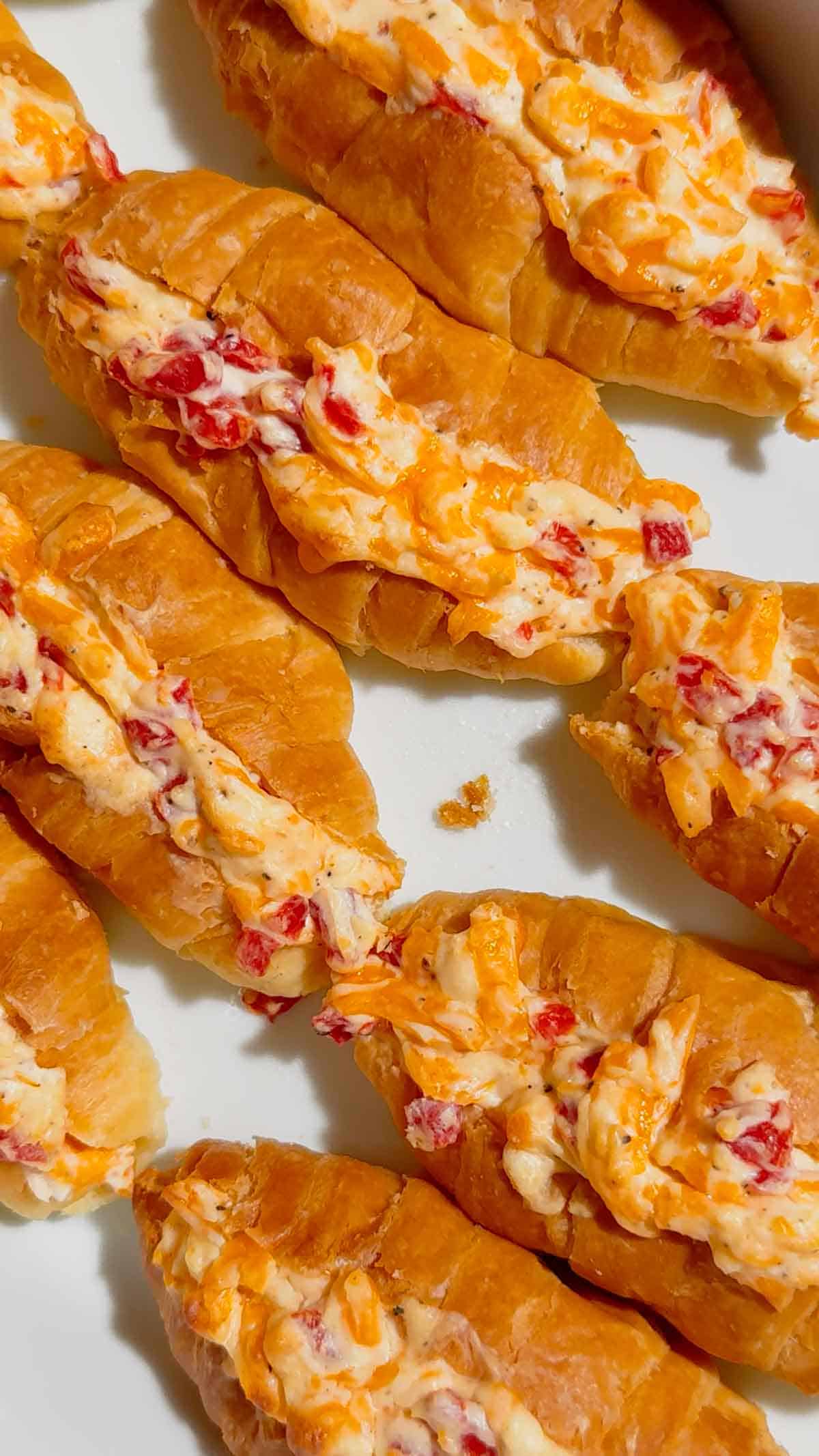 These Pimento Cheese Mini Croissants are the ultimate easy party appetizer for holidays, game day spreads, brunch tables and casual entertaining. Mini butter croissants are sliced open and stuffed with creamy homemade pimento cheese made with sharp cheddar, mayo, cream cheese and diced pimentos, then baked until warm, melty and golden brown. These cheesy baked croissant sandwiches are rich, buttery and packed with bold Southern-inspired flavour in every bite. Perfect for make ahead entertaining, easy finger foods, football snacks, brunch recipes, appetizer trays and quick baked party food ideas. If you love easy croissant recipes, cheesy appetizers, baked sandwiches and crowd pleasing snacks, this easy recipe is a must try.