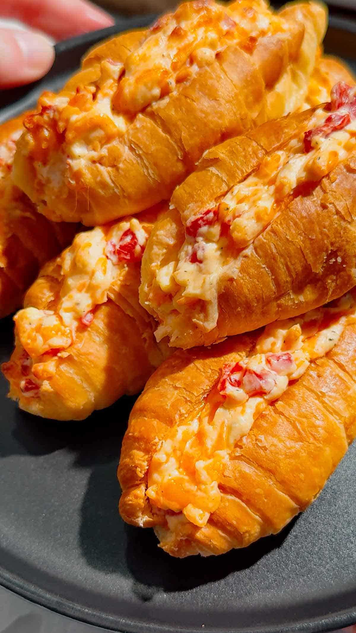 These Pimento Cheese Mini Croissants are the ultimate easy party appetizer for holidays, game day spreads, brunch tables and casual entertaining. Mini butter croissants are sliced open and stuffed with creamy homemade pimento cheese made with sharp cheddar, mayo, cream cheese and diced pimentos, then baked until warm, melty and golden brown. These cheesy baked croissant sandwiches are rich, buttery and packed with bold Southern-inspired flavour in every bite. Perfect for make ahead entertaining, easy finger foods, football snacks, brunch recipes, appetizer trays and quick baked party food ideas. If you love easy croissant recipes, cheesy appetizers, baked sandwiches and crowd pleasing snacks, this easy recipe is a must try.