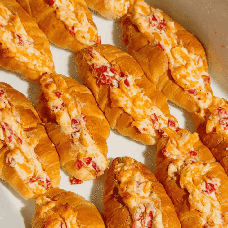 These Pimento Cheese Mini Croissants are the ultimate easy party appetizer for holidays, game day spreads, brunch tables and casual entertaining. Mini butter croissants are sliced open and stuffed with creamy homemade pimento cheese made with sharp cheddar, mayo, cream cheese and diced pimentos, then baked until warm, melty and golden brown. These cheesy baked croissant sandwiches are rich, buttery and packed with bold Southern-inspired flavour in every bite. Perfect for make ahead entertaining, easy finger foods, football snacks, brunch recipes, appetizer trays and quick baked party food ideas. If you love easy croissant recipes, cheesy appetizers, baked sandwiches and crowd pleasing snacks, this easy recipe is a must try.