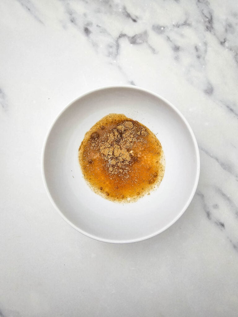 cider vinegar added to a mixing bowl with seasonings