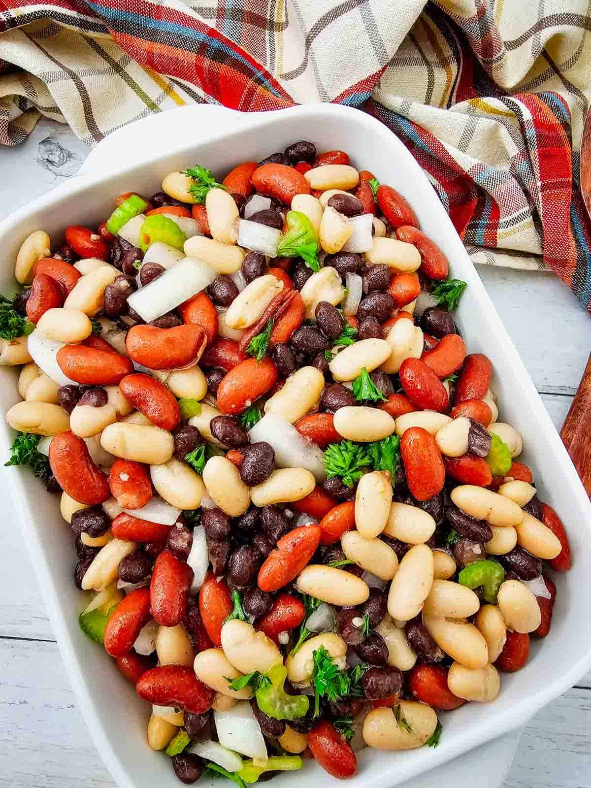 Looking for the perfect Three Bean Salad Recipe to serve at your next barbecue, picnic, or potluck? This easy Classic Three Bean Salad is loaded with kidney beans, cannellini beans, black beans, crisp celery, onion, fresh parsley, and a sweet tangy homemade dressing. It's one of the best Cold Bean Salad Recipes because it's quick to make, packed with protein and fiber, and tastes even better after chilling. Whether you need Summer Side Dishes, BBQ Side Dishes, Picnic Food Ideas, Potluck Side Dishes, Healthy Bean Salad, Make Ahead Salad Recipes, or easy Cookout Side Dishes, this fresh and flavorful bean salad is a crowd-pleasing favorite that's perfect for family dinners, holidays, and warm weather entertaining.