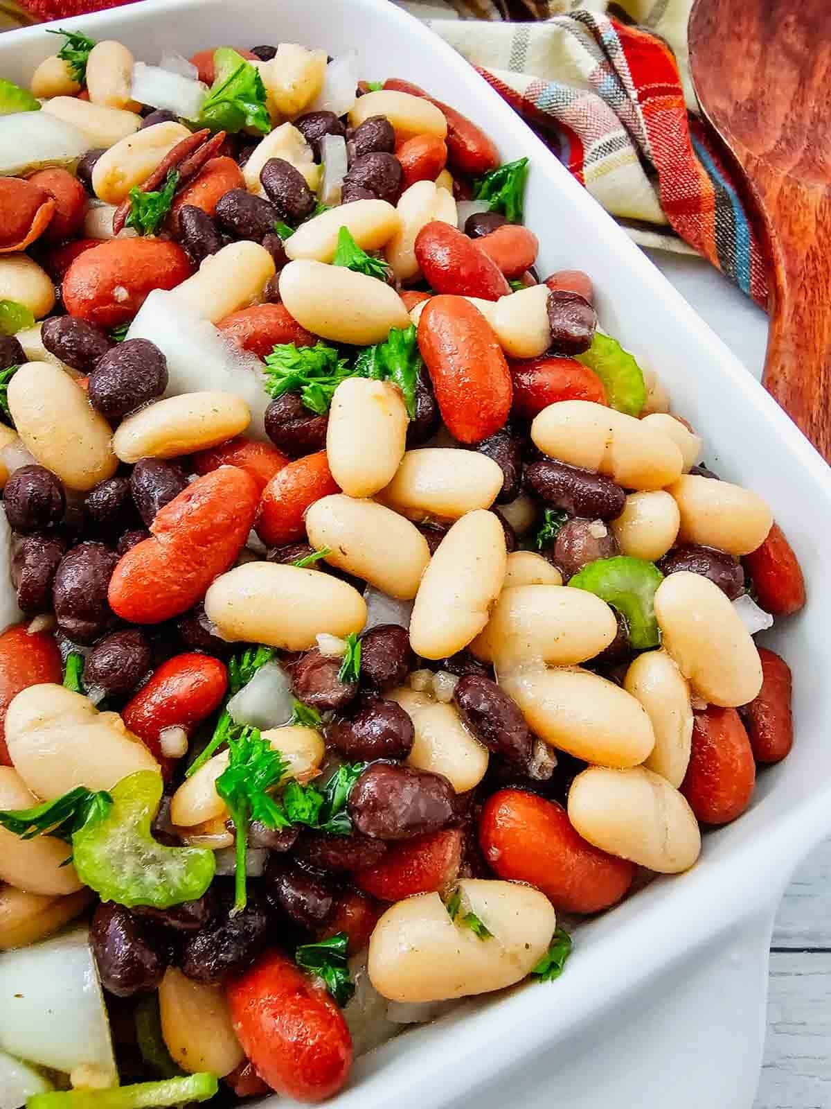 Looking for the perfect Three Bean Salad Recipe to serve at your next barbecue, picnic, or potluck? This easy Classic Three Bean Salad is loaded with kidney beans, cannellini beans, black beans, crisp celery, onion, fresh parsley, and a sweet tangy homemade dressing. It's one of the best Cold Bean Salad Recipes because it's quick to make, packed with protein and fiber, and tastes even better after chilling. Whether you need Summer Side Dishes, BBQ Side Dishes, Picnic Food Ideas, Potluck Side Dishes, Healthy Bean Salad, Make Ahead Salad Recipes, or easy Cookout Side Dishes, this fresh and flavorful bean salad is a crowd-pleasing favorite that's perfect for family dinners, holidays, and warm weather entertaining.