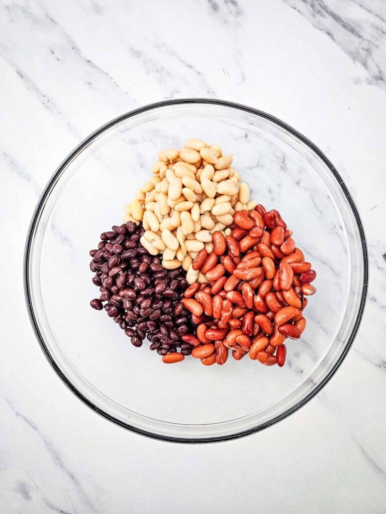 black beans, cannellini beans and kidney beans in a glass mixing bowl