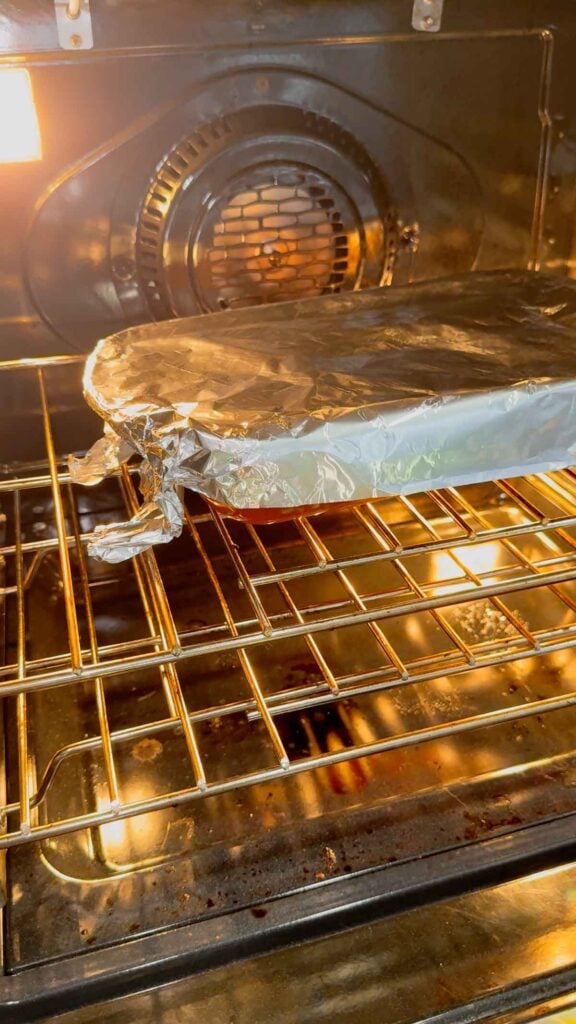 foil covered baking dish in the oven