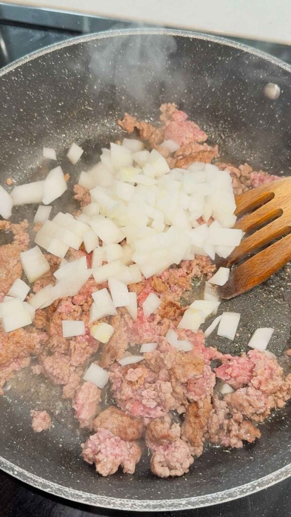 diced onions added to skillet with ground beef