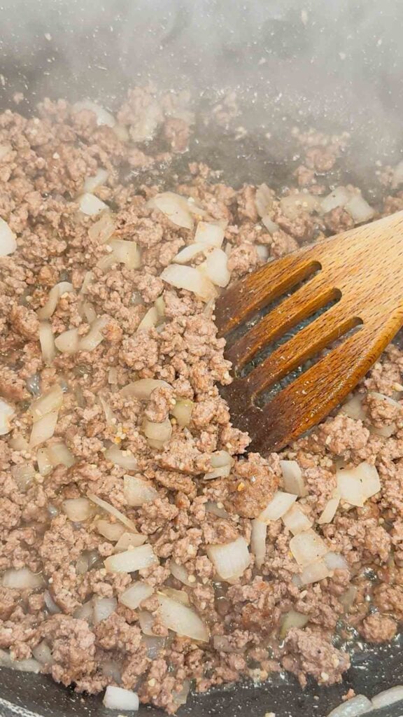 cooked ground beef and diced onions in a baking dish
