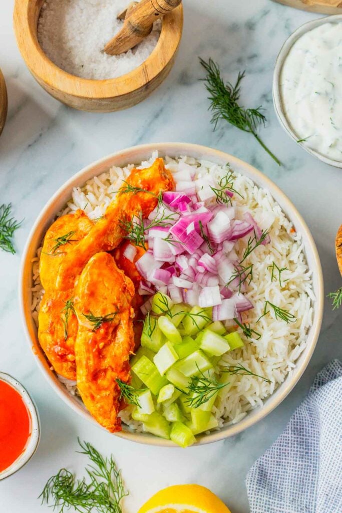 This Buffalo Chicken Bowl is the ultimate easy dinner recipe for busy weeknights, meal prep lunches, and game day food cravings. Tender chicken tossed in spicy Buffalo sauce is served over fluffy white rice and topped with crisp celery, red onion, and a creamy homemade ranch dressing for the perfect balance of heat and freshness. If you're looking for healthy chicken bowl recipes, Buffalo chicken rice bowls, easy meal prep ideas, or quick family dinner recipes, this dish checks every box. Packed with protein, loaded with flavor, and ready in just 30 minutes, these Buffalo Chicken Bowls are a satisfying comfort food meal that feels restaurant-worthy while being simple enough to make at home any night of the week.
