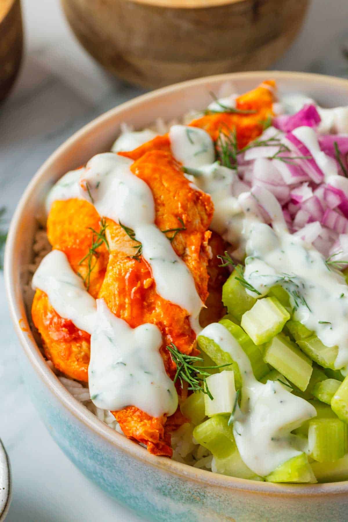 This Buffalo Chicken Bowl is the ultimate easy dinner recipe for busy weeknights, meal prep lunches, and game day food cravings. Tender chicken tossed in spicy Buffalo sauce is served over fluffy white rice and topped with crisp celery, red onion, and a creamy homemade ranch dressing for the perfect balance of heat and freshness. If you're looking for healthy chicken bowl recipes, Buffalo chicken rice bowls, easy meal prep ideas, or quick family dinner recipes, this dish checks every box. Packed with protein, loaded with flavor, and ready in just 30 minutes, these Buffalo Chicken Bowls are a satisfying comfort food meal that feels restaurant-worthy while being simple enough to make at home any night of the week.