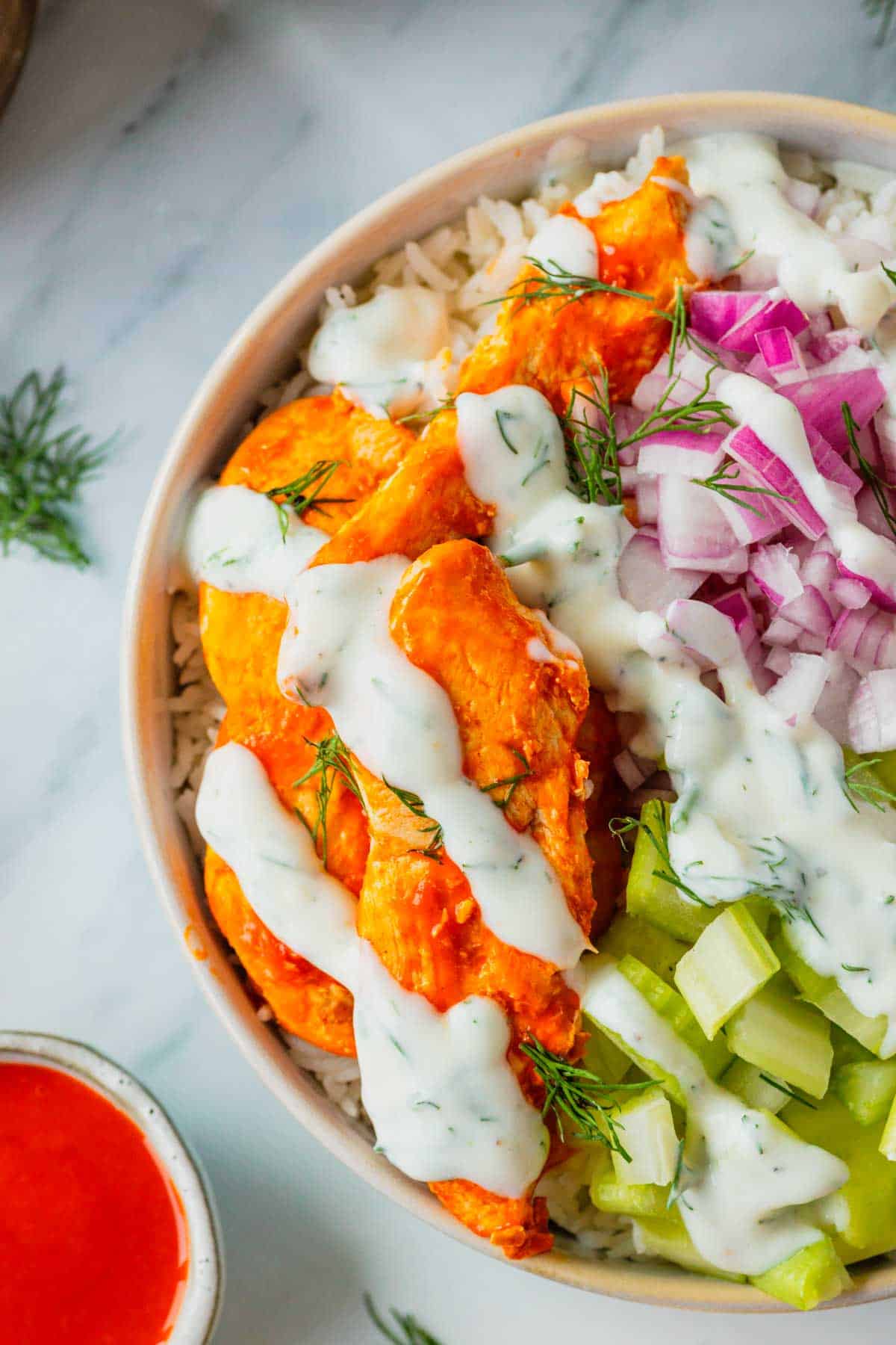 This Buffalo Chicken Bowl is the ultimate easy dinner recipe for busy weeknights, meal prep lunches, and game day food cravings. Tender chicken tossed in spicy Buffalo sauce is served over fluffy white rice and topped with crisp celery, red onion, and a creamy homemade ranch dressing for the perfect balance of heat and freshness. If you're looking for healthy chicken bowl recipes, Buffalo chicken rice bowls, easy meal prep ideas, or quick family dinner recipes, this dish checks every box. Packed with protein, loaded with flavor, and ready in just 30 minutes, these Buffalo Chicken Bowls are a satisfying comfort food meal that feels restaurant-worthy while being simple enough to make at home any night of the week.