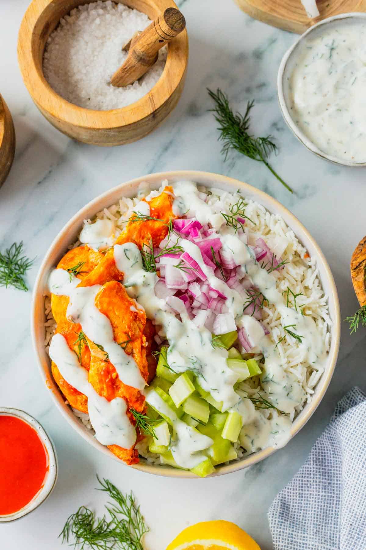 This Buffalo Chicken Bowl is the ultimate easy dinner recipe for busy weeknights, meal prep lunches, and game day food cravings. Tender chicken tossed in spicy Buffalo sauce is served over fluffy white rice and topped with crisp celery, red onion, and a creamy homemade ranch dressing for the perfect balance of heat and freshness. If you're looking for healthy chicken bowl recipes, Buffalo chicken rice bowls, easy meal prep ideas, or quick family dinner recipes, this dish checks every box. Packed with protein, loaded with flavor, and ready in just 30 minutes, these Buffalo Chicken Bowls are a satisfying comfort food meal that feels restaurant-worthy while being simple enough to make at home any night of the week.