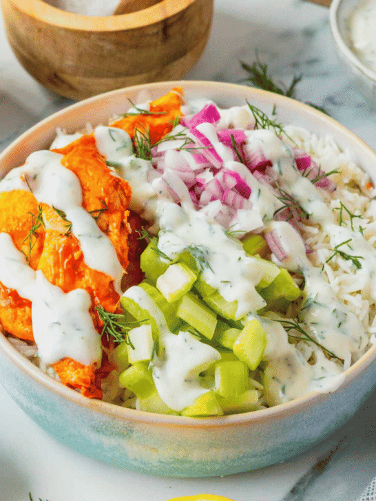 This Buffalo Chicken Bowl is the ultimate easy dinner recipe for busy weeknights, meal prep lunches, and game day food cravings. Tender chicken tossed in spicy Buffalo sauce is served over fluffy white rice and topped with crisp celery, red onion, and a creamy homemade ranch dressing for the perfect balance of heat and freshness. If you're looking for healthy chicken bowl recipes, Buffalo chicken rice bowls, easy meal prep ideas, or quick family dinner recipes, this dish checks every box. Packed with protein, loaded with flavor, and ready in just 30 minutes, these Buffalo Chicken Bowls are a satisfying comfort food meal that feels restaurant-worthy while being simple enough to make at home any night of the week.