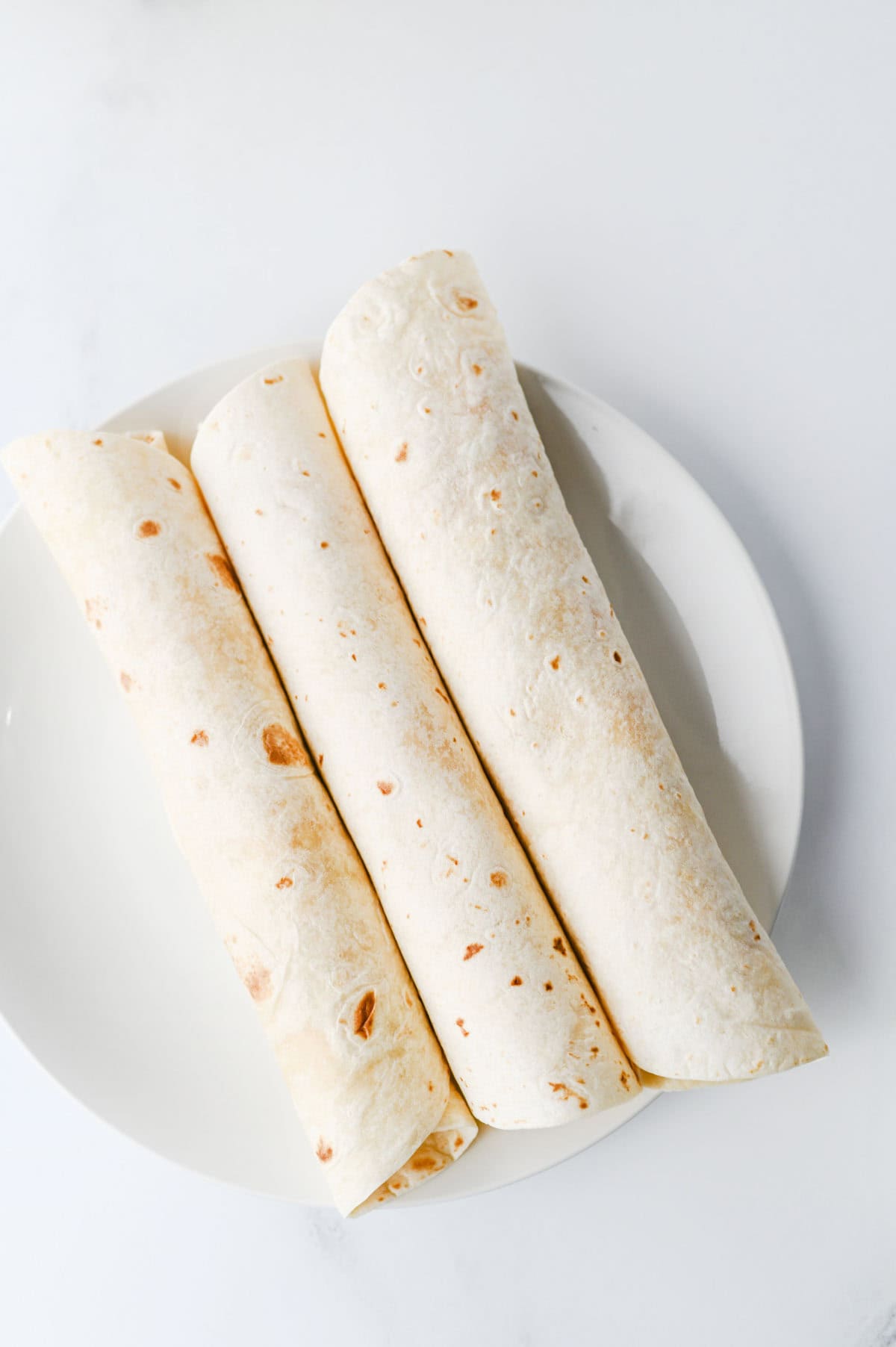 rolled flour tortillas on a plate