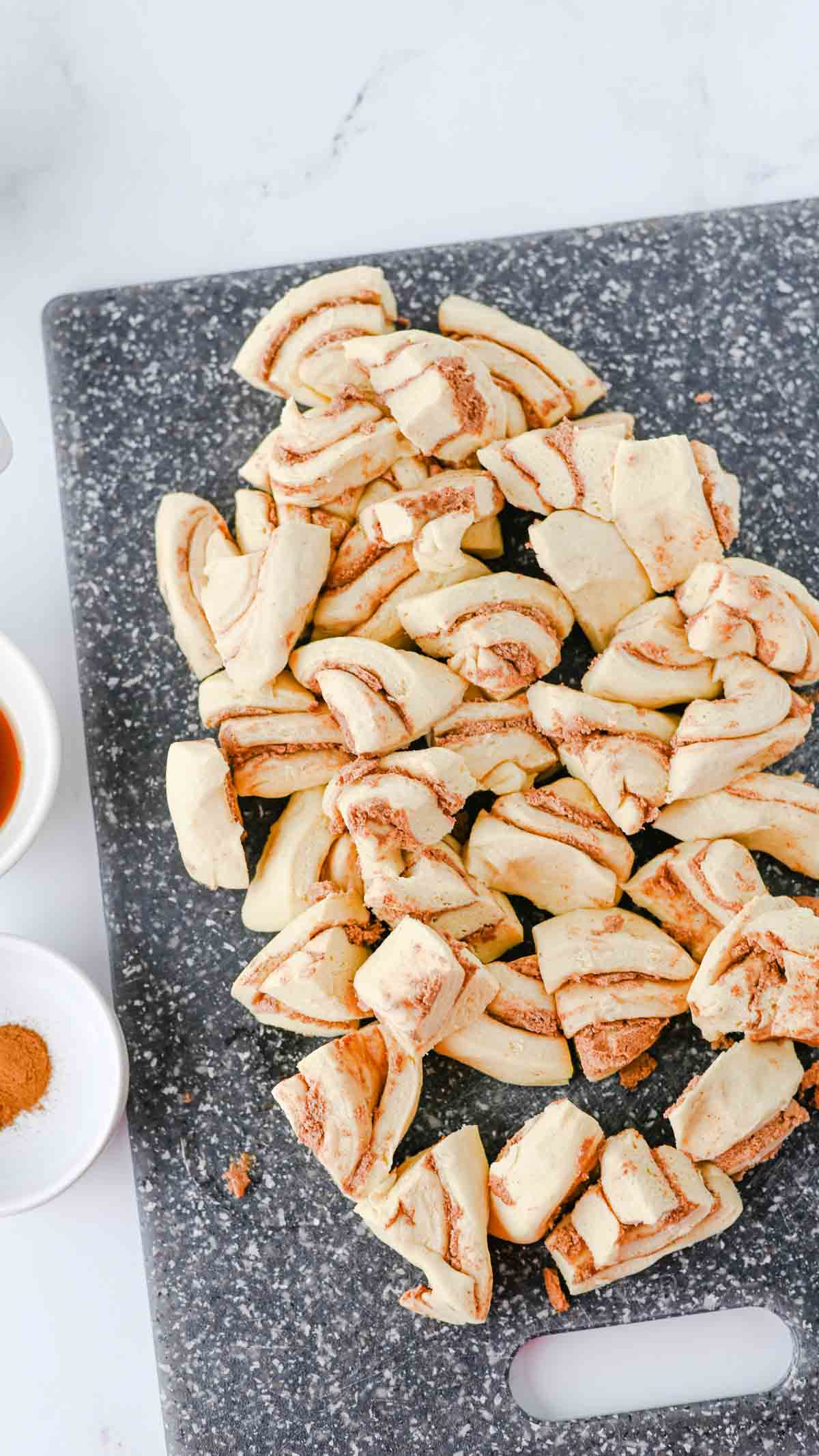 chopped cinnamon roll dough on a cutting board