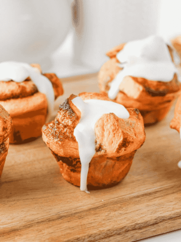 These Cinnamon Roll Muffins are the ultimate easy breakfast recipe for busy mornings, holiday brunches and weekend baking. Made with Pillsbury cinnamon rolls, eggs, heavy cream, cinnamon and vanilla, these soft and fluffy muffins have all the flavour of classic cinnamon rolls in a convenient grab-and-go form. The chopped cinnamon roll pieces bake up perfectly in muffin tins while the rich custard mixture creates a tender, bakery-style texture. Once baked, they're topped with the sweet cream cheese frosting for an irresistible finish. Whether you're looking for an easy brunch recipe, a simple make-ahead breakfast or a fun twist on canned cinnamon rolls, these Cinnamon Roll Muffins are guaranteed to be a family favourite.