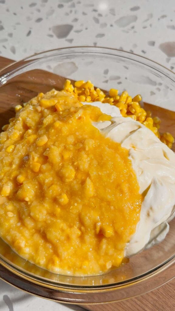 cream style corn on top of mayo, sour cream and corn in a mixing bowl