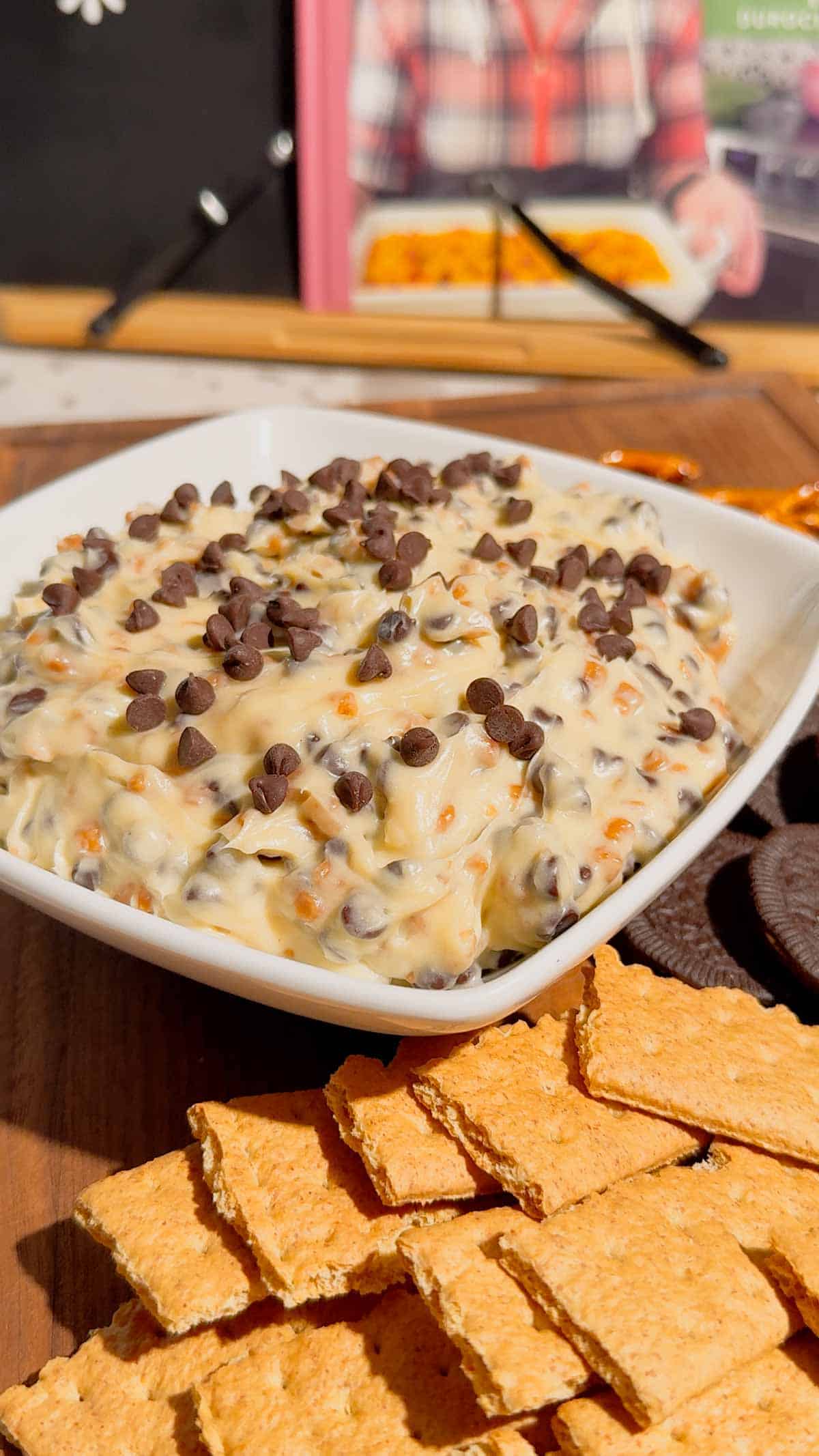 Looking for the ultimate Cookie Dough Dip recipe? This easy No Bake Dessert Dip is rich, creamy, and loaded with mini chocolate chips and crunchy toffee bits for the perfect sweet treat. Ready in just 10 minutes, this Chocolate Chip Cookie Dough Dip is ideal for parties, game day, movie nights, birthdays, potlucks, holiday dessert tables, and family gatherings. Serve it with graham crackers, vanilla wafers, pretzels, apple slices, strawberries, or cookies for an irresistible dessert everyone will love. If you need an easy dessert dip, sweet party snack, no bake dessert recipe, or crowd-pleasing treat, this homemade cookie dough dip is guaranteed to disappear fast and become a favorite for every occasion.