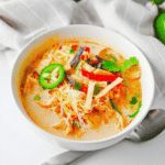 Warm up with this easy Crock Pot Chicken Tortilla Soup, a creamy and comforting dinner loaded with shredded chicken, black beans, pinto beans, corn, peppers, and bold Tex-Mex flavor. This Slow Cooker Chicken Tortilla Soup is the perfect dump-and-go meal for busy weeknights, meal prep, or cozy family dinners. Made with enchilada sauce, taco seasoning, and a splash of half and half, every spoonful is rich, hearty, and satisfying. Top it with crispy tortilla strips, shredded cheese, sour cream, avocado, or jalapeños for the ultimate bowl. If you're looking for easy crock pot soup recipes, slow cooker chicken recipes, or comforting fall and winter dinner ideas, this Chicken Tortilla Soup recipe is guaranteed to become a family favorite you'll make again and again.