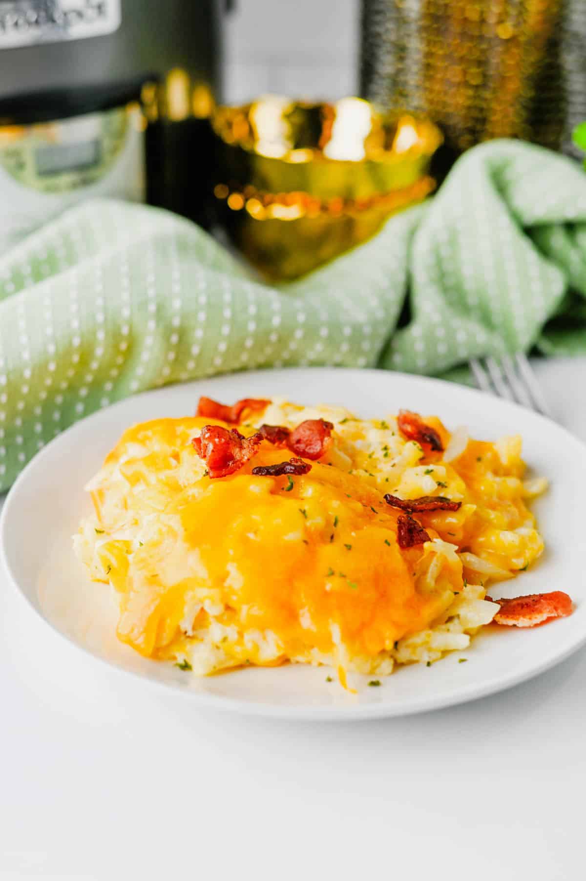 This Crock Pot Cheesy Bacon Hashbrown Casserole is the ultimate comfort food side dish for holidays, potlucks, family dinners, and busy weeknights. Loaded with frozen hashbrowns, crispy bacon, cheddar cheese, sour cream, and a rich homemade cheese sauce, this Slow Cooker Hashbrown Casserole is creamy, hearty, and packed with flavor. If you're searching for Crockpot Potato Recipes, Cheesy Hashbrown Casserole, Funeral Potatoes, Slow Cooker Side Dishes, Potato Casserole Recipes, Crock Pot Potatoes, Easy Holiday Side Dishes, Make Ahead Side Dishes, or Easy Potluck Recipes, this recipe is a must-try. Perfect for Thanksgiving, Christmas, Easter, brunch gatherings, and comfort food dinners, this cheesy bacon potato casserole always disappears fast.