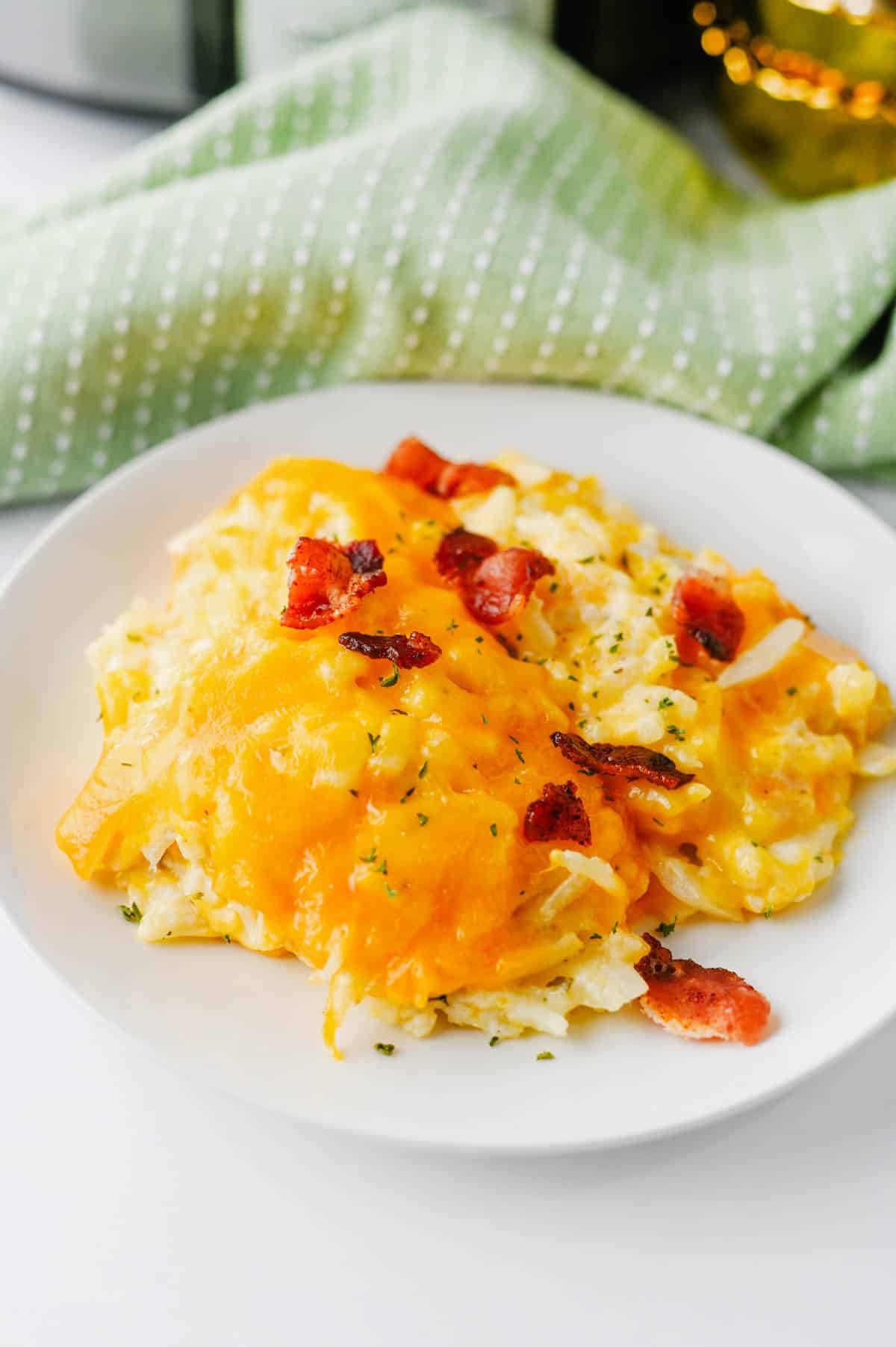 This Crock Pot Cheesy Bacon Hashbrown Casserole is the ultimate comfort food side dish for holidays, potlucks, family dinners, and busy weeknights. Loaded with frozen hashbrowns, crispy bacon, cheddar cheese, sour cream, and a rich homemade cheese sauce, this Slow Cooker Hashbrown Casserole is creamy, hearty, and packed with flavor. If you're searching for Crockpot Potato Recipes, Cheesy Hashbrown Casserole, Funeral Potatoes, Slow Cooker Side Dishes, Potato Casserole Recipes, Crock Pot Potatoes, Easy Holiday Side Dishes, Make Ahead Side Dishes, or Easy Potluck Recipes, this recipe is a must-try. Perfect for Thanksgiving, Christmas, Easter, brunch gatherings, and comfort food dinners, this cheesy bacon potato casserole always disappears fast.