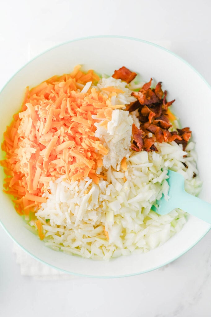 frozen hashbrowns, cooked bacon, shredded cheddar and sour cream in a mixing bowl