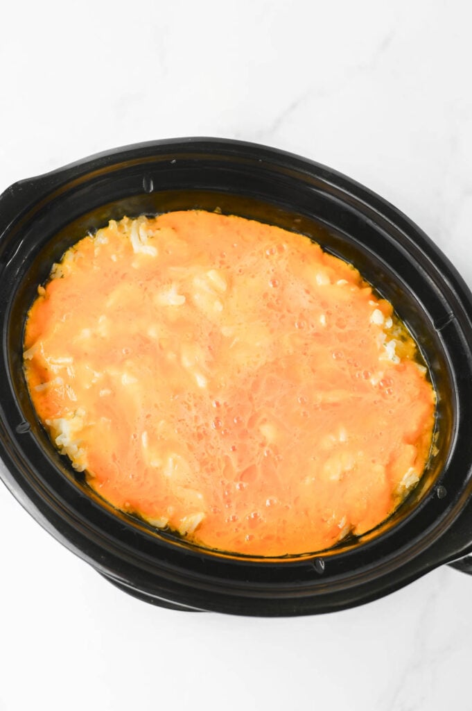 melted cheddar on top of hashbrown casserole in a crockpot
