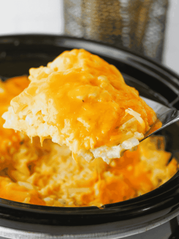 This Crock Pot Cheesy Bacon Hashbrown Casserole is the ultimate comfort food side dish for holidays, potlucks, family dinners, and busy weeknights. Loaded with frozen hashbrowns, crispy bacon, cheddar cheese, sour cream, and a rich homemade cheese sauce, this Slow Cooker Hashbrown Casserole is creamy, hearty, and packed with flavor. If you're searching for Crockpot Potato Recipes, Cheesy Hashbrown Casserole, Funeral Potatoes, Slow Cooker Side Dishes, Potato Casserole Recipes, Crock Pot Potatoes, Easy Holiday Side Dishes, Make Ahead Side Dishes, or Easy Potluck Recipes, this recipe is a must-try. Perfect for Thanksgiving, Christmas, Easter, brunch gatherings, and comfort food dinners, this cheesy bacon potato casserole always disappears fast.