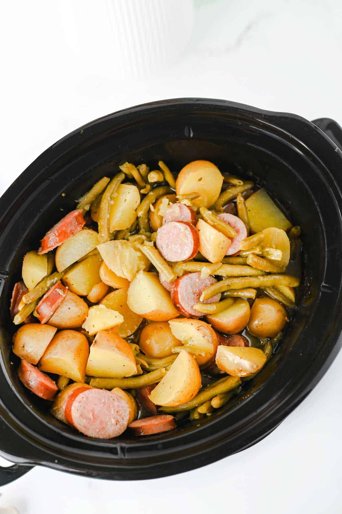 Looking for an easy slow cooker dinner the whole family will love? These Crock Pot Swamp Potatoes are loaded with tender baby potatoes, smoky sausage, green beans, buttery ranch flavor, and a kick of Cajun seasoning for a hearty meal that's packed with comfort. Everything cooks together in the crock pot, making this one of the easiest dump-and-go recipes for busy weeknights, lazy weekends, or cozy family dinners. If you love simple slow cooker recipes, sausage and potatoes, one pot meals, Southern-inspired comfort food, and budget-friendly dinners, this recipe deserves a spot on your menu. Serve it with crusty bread or enjoy it as a complete meal that's filling, flavorful, and guaranteed to have everyone coming back for seconds.